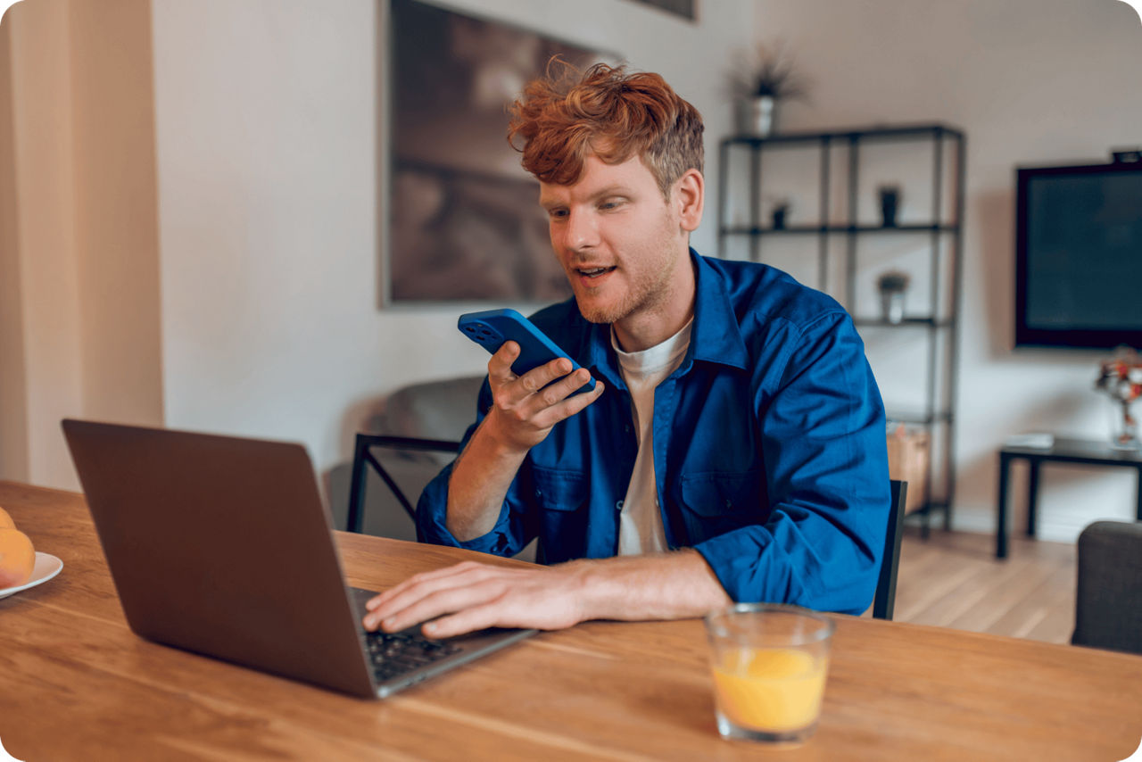 Ein junger Unternhemer sitzt vor seinem Notebook und telefoniert