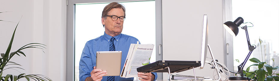 Ein Mann in blauem Hemd und Krawatte steht in einem modernen Büro