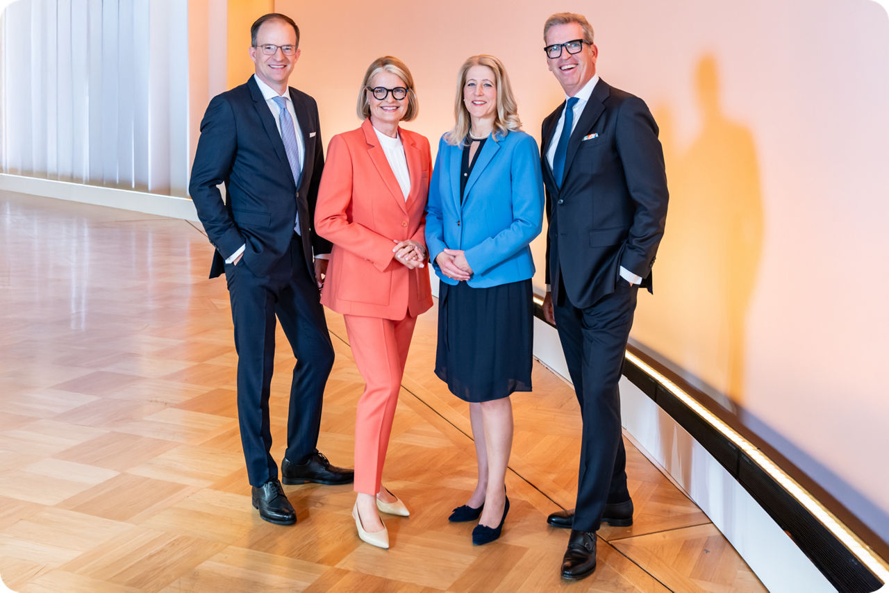 Die vier Vorstände der Berliner Volksbank stehen in einem Saal