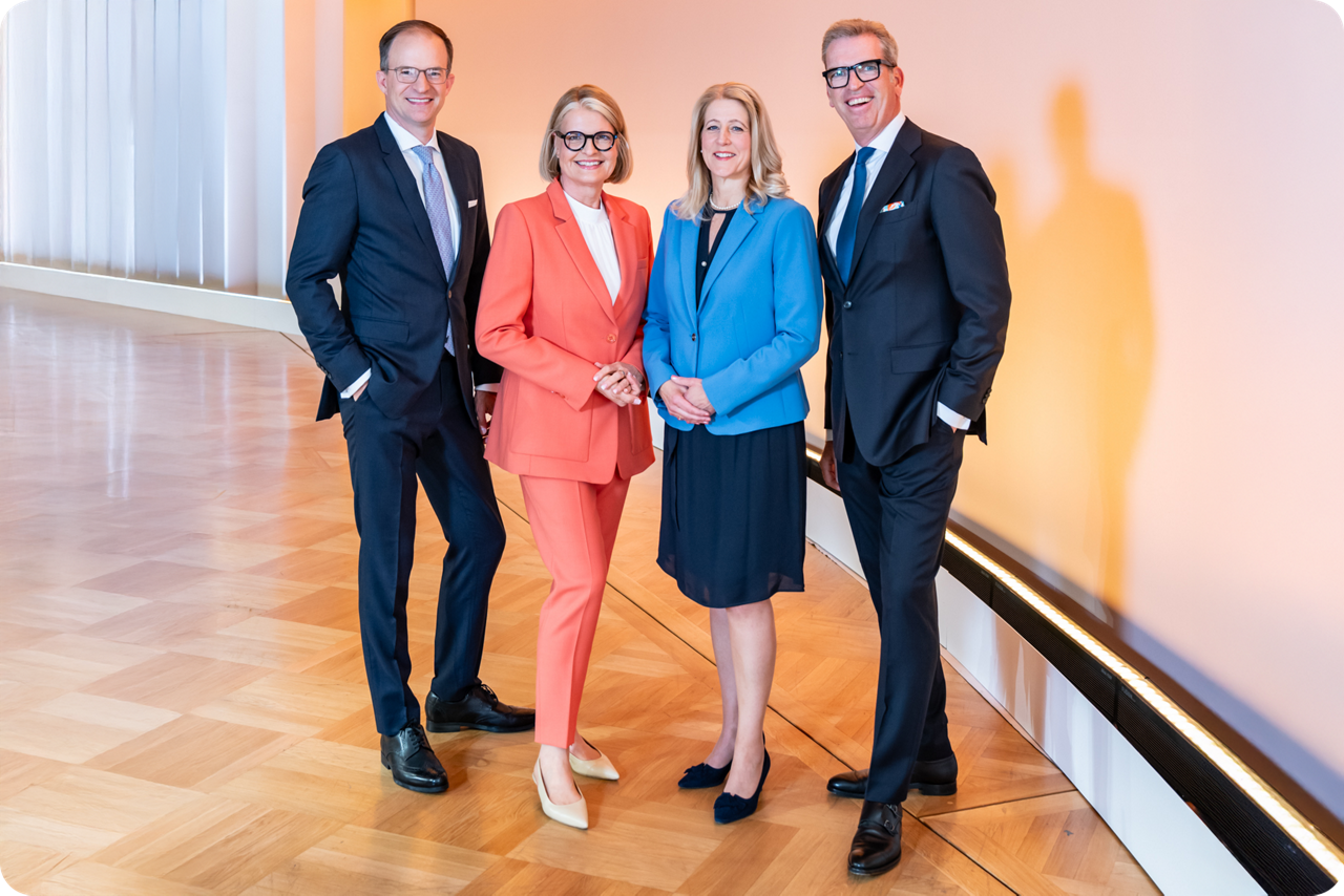 Die vier Vorstände der Berliner Volksbank stehen in einem Saal