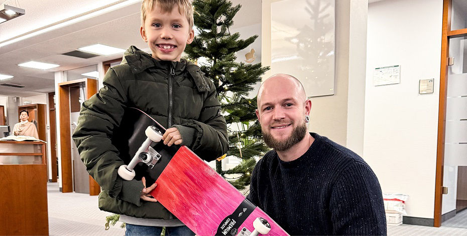 Mann übergibt Weihnachtsgeschenk an Kind