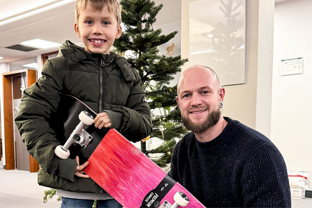 Mann übergibt Weihnachtsgeschenk an Kind