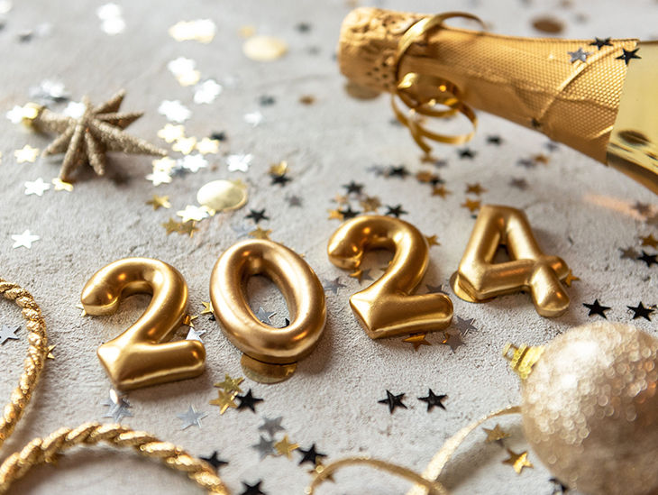 Goldene Zahlen '2024' auf einem gedeckten Tisch im Silvester-Look