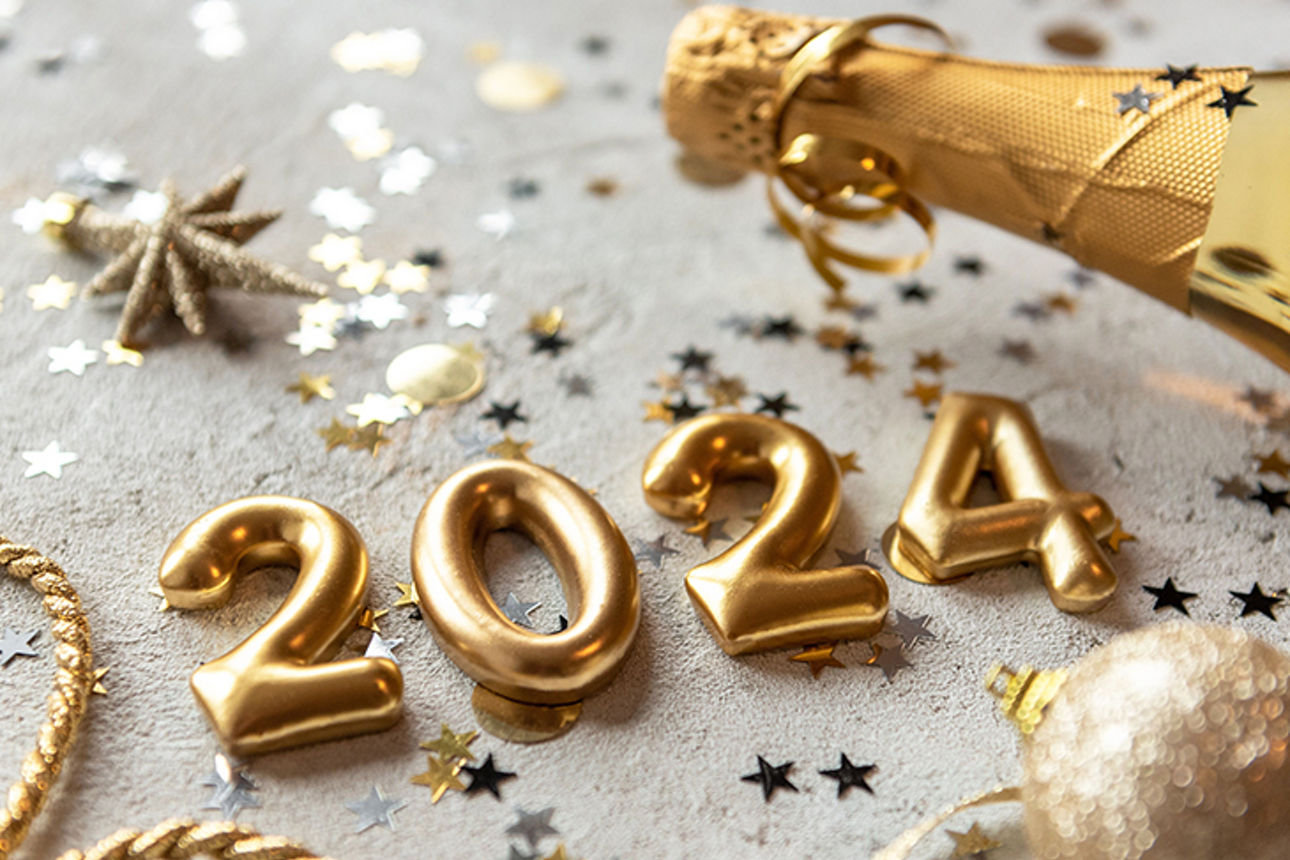 Goldene Zahlen '2024' auf einem gedeckten Tisch im Silvester-Look