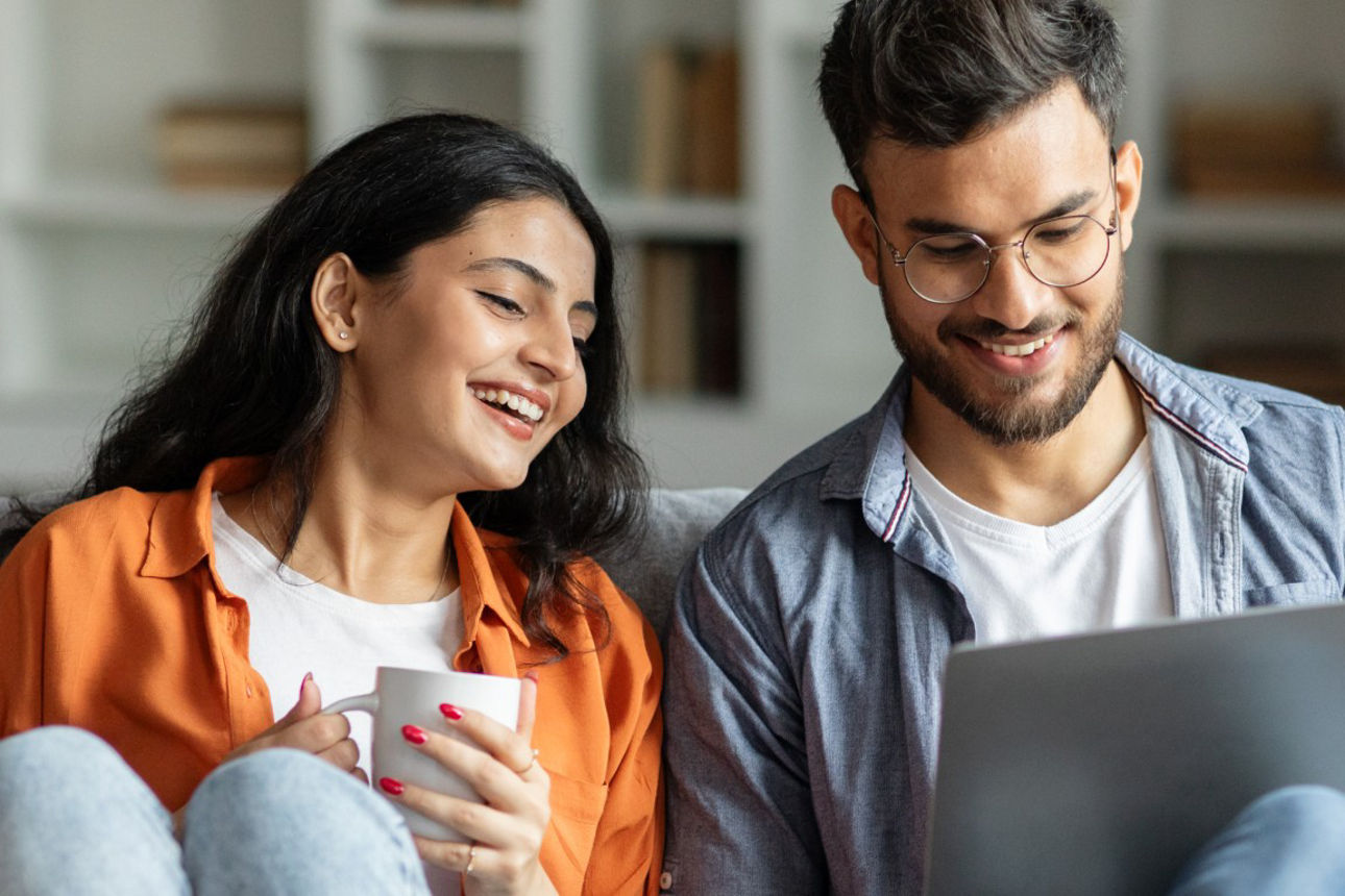 Junges Pärchen mit Laptop auf Sofa