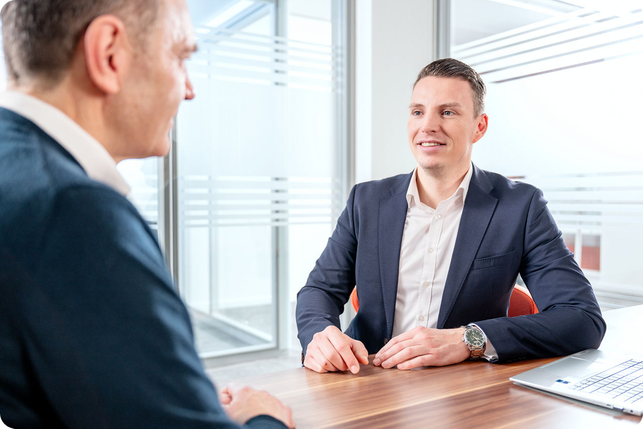 Ein Berater und ein Kunden haben ein Beratungsgespräch zur gewerbliche Immobilienfinanzierung