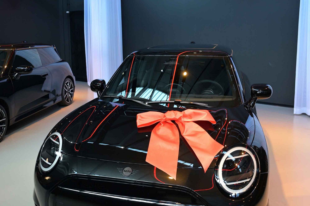 Ein schwarzer "Mini" Auto mit einer Schleife