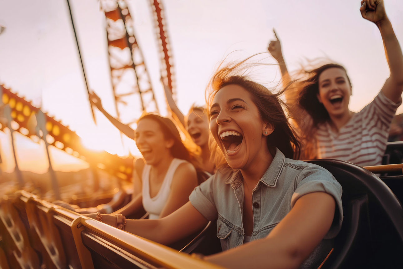 Freunde fahren jubelnd zusammen Achterbahn