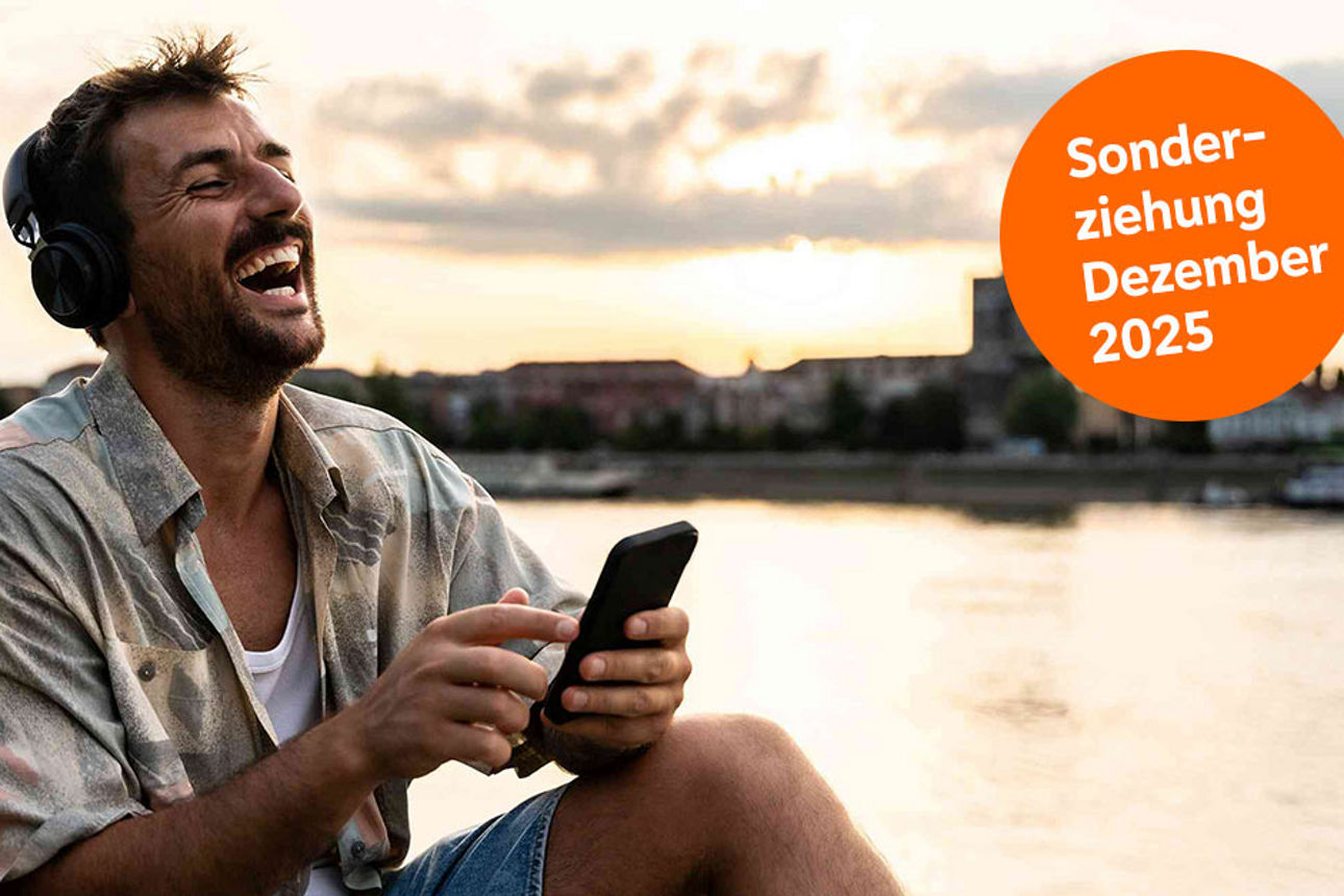 Mann lacht mit Handy in der Hand