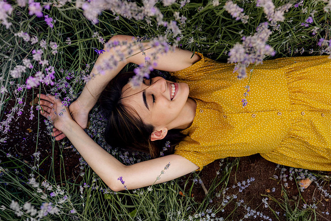Eine junge Frau liegt auf einer Blumenwiese