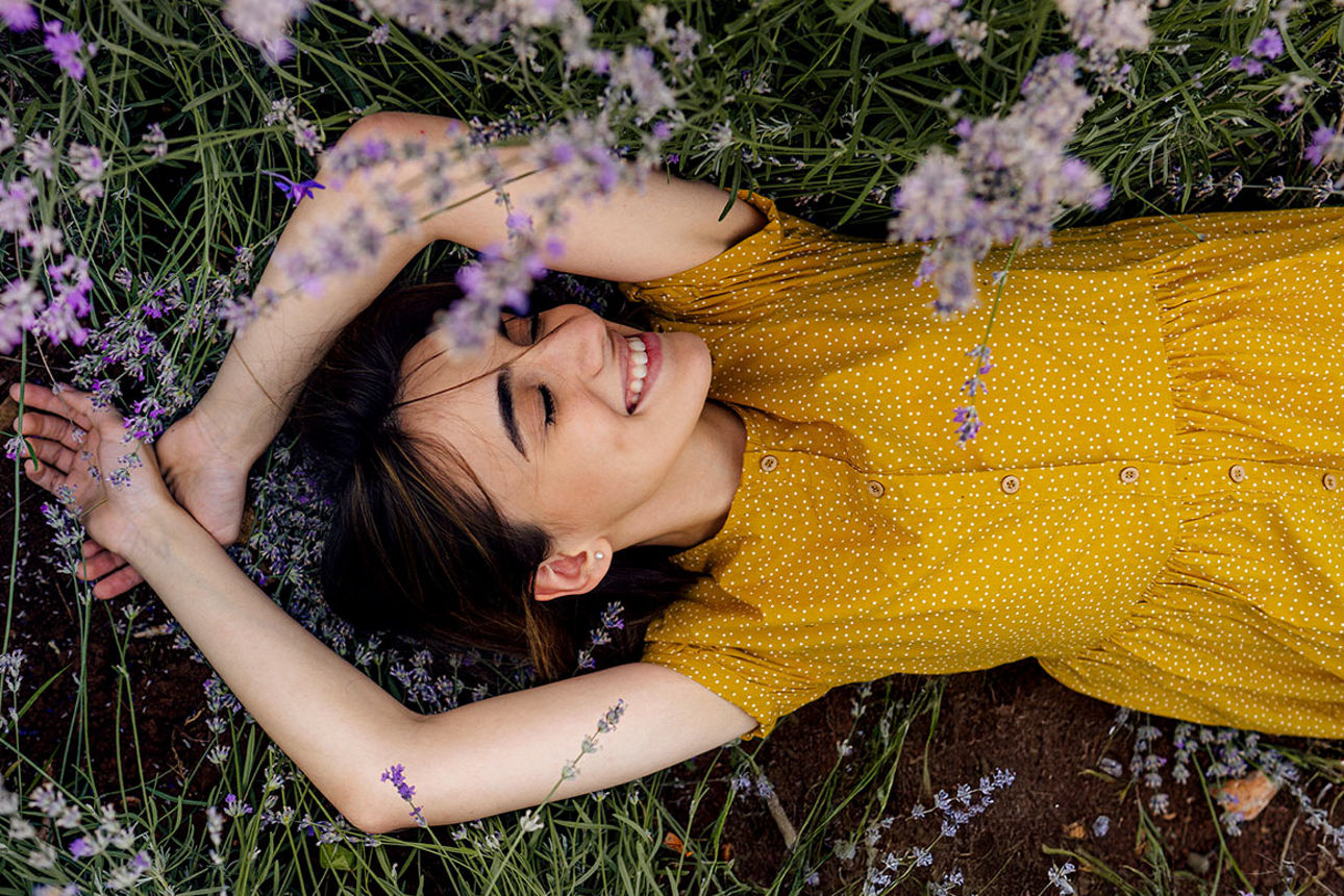 Frau liegt auf einer Blumenwiese