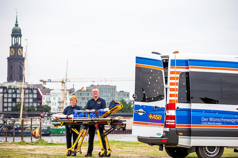 Michel im Hintergrund des ASB Wünschewagen