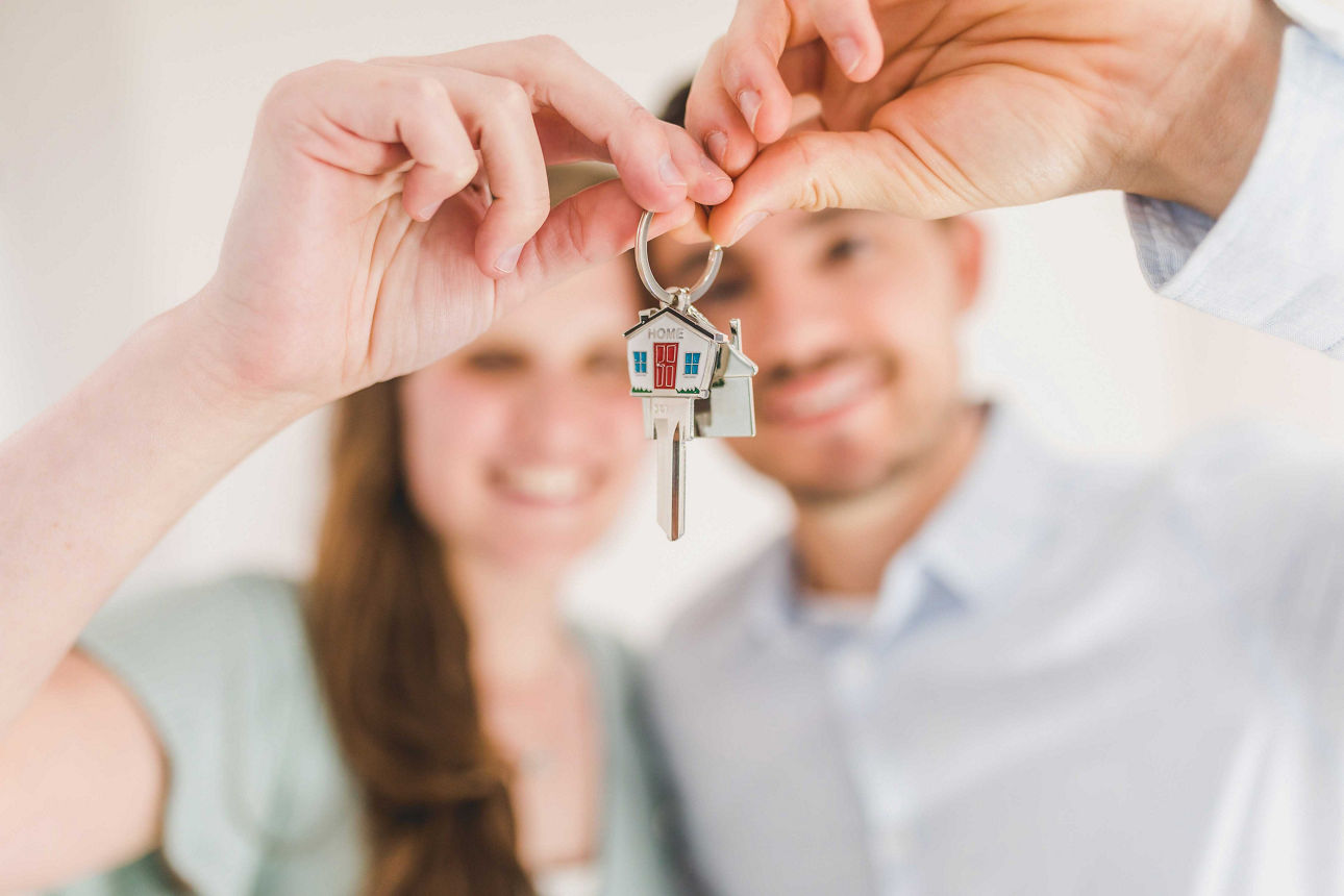 Ein Mann und eine Frau halten zusammen einen Wohnungsschlüssel in der Hand