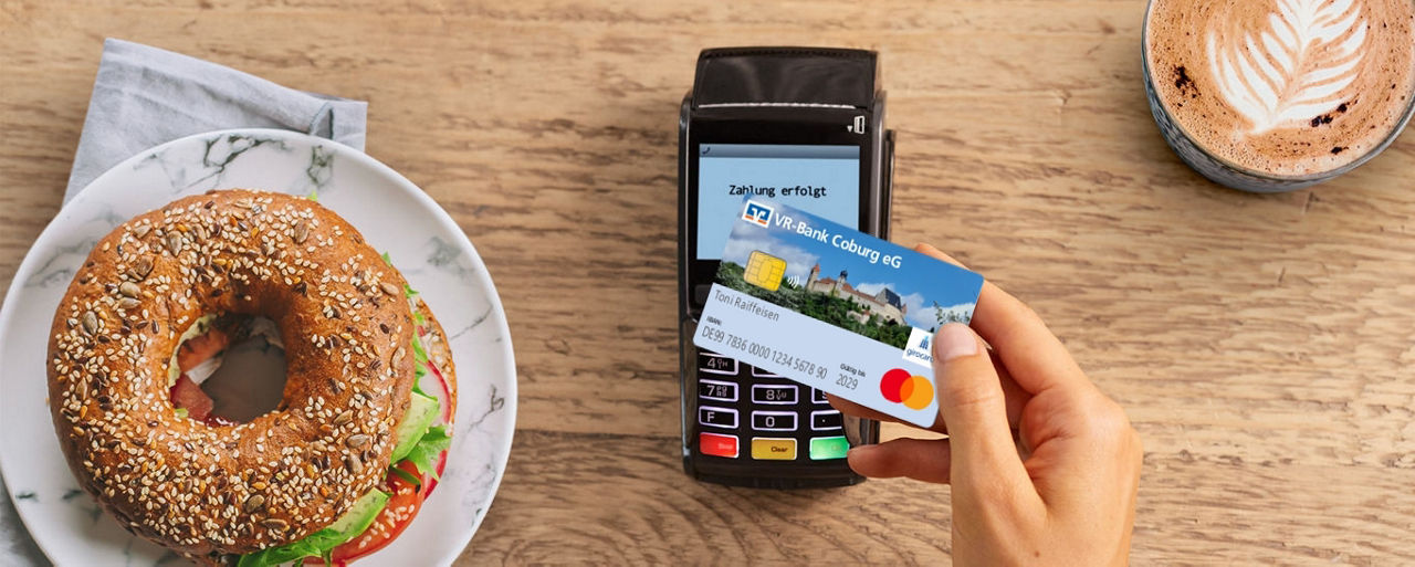 Ein Bagel und ein Kaffee werden kontaktlos mit der girocard bezahlt