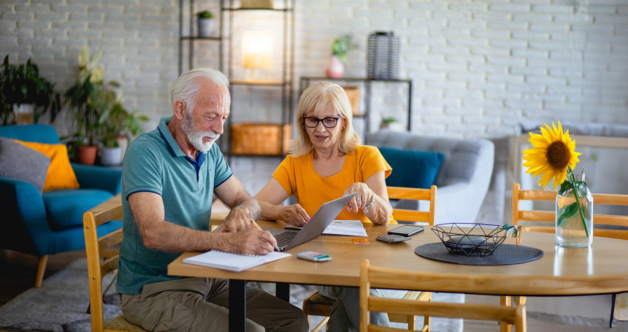 Ehepaar sitzt am Tisch und macht OnlineBanking