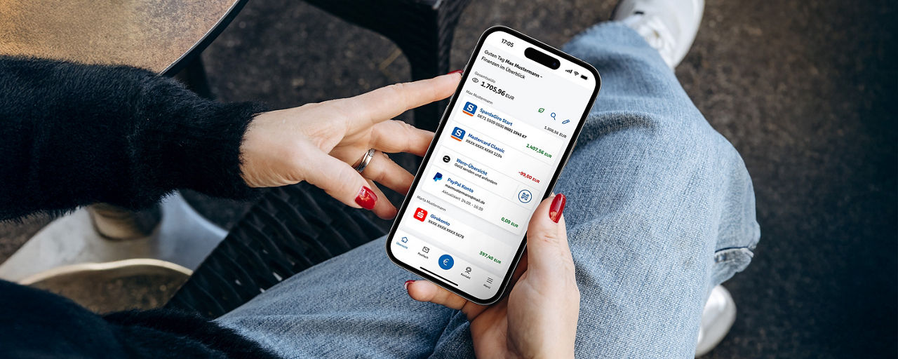 Person nutzt die Banking App auf einem iPhone