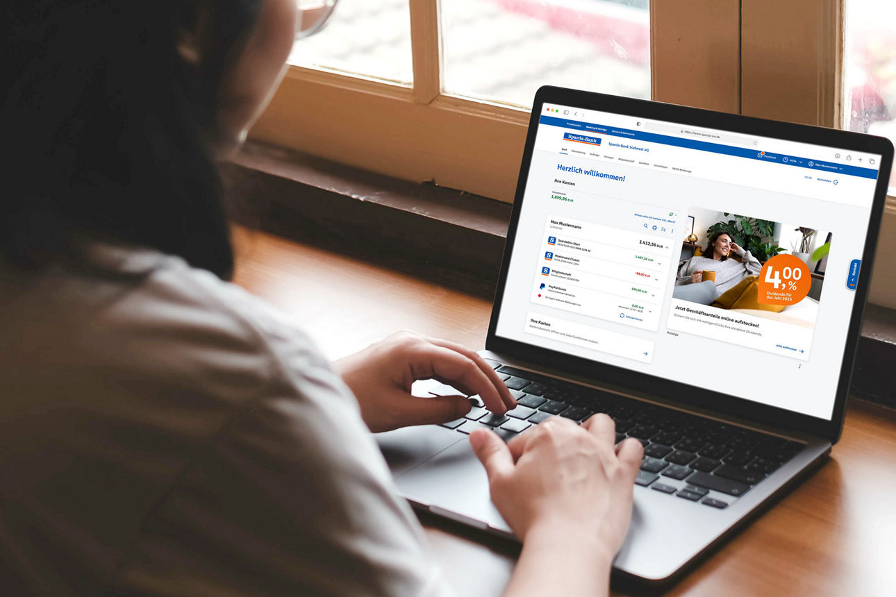 Frau sitzt in der Küche und erledigt mit unserem TÜV-zertifierierten Online-Banking ihre Finanzen