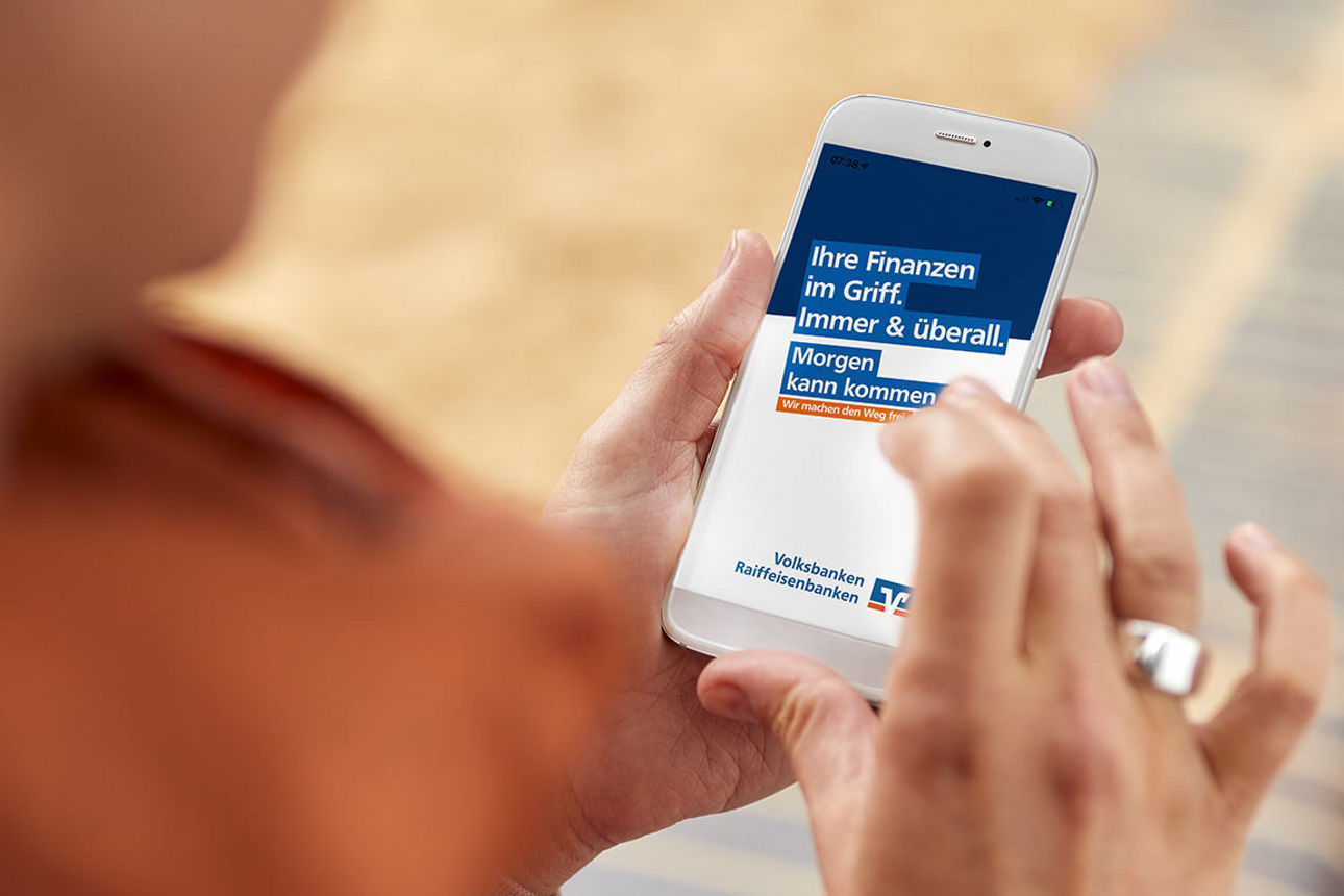 Frau schaut auf die VR Banking App in ihrem Smartphone