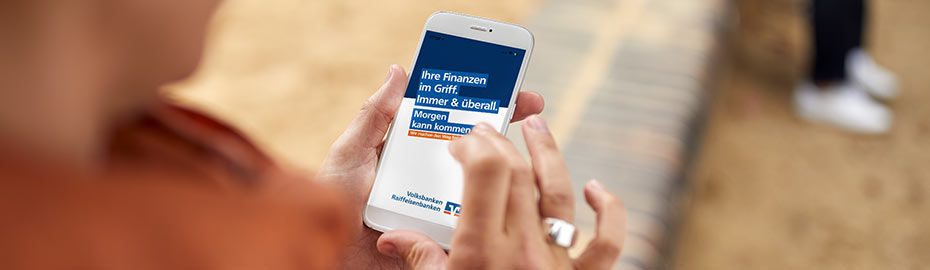 Mensch öffnet auf dem Handy die Seite "Der Morgen kann kommen"