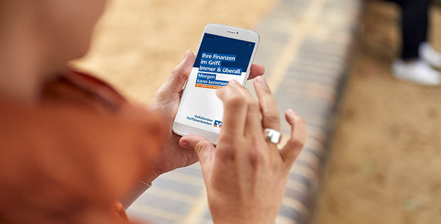 Frau schaut auf die VR Banking App in ihrem Smartphone