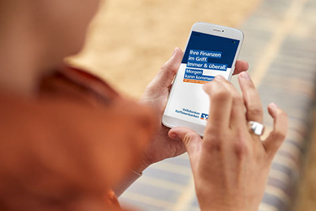 Frau schaut auf die VR Banking App in ihrem Smartphone