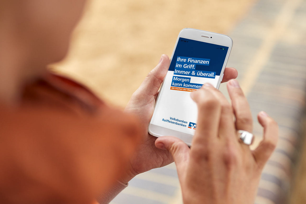 Frau schaut auf die VR Banking App in ihrem Smartphone