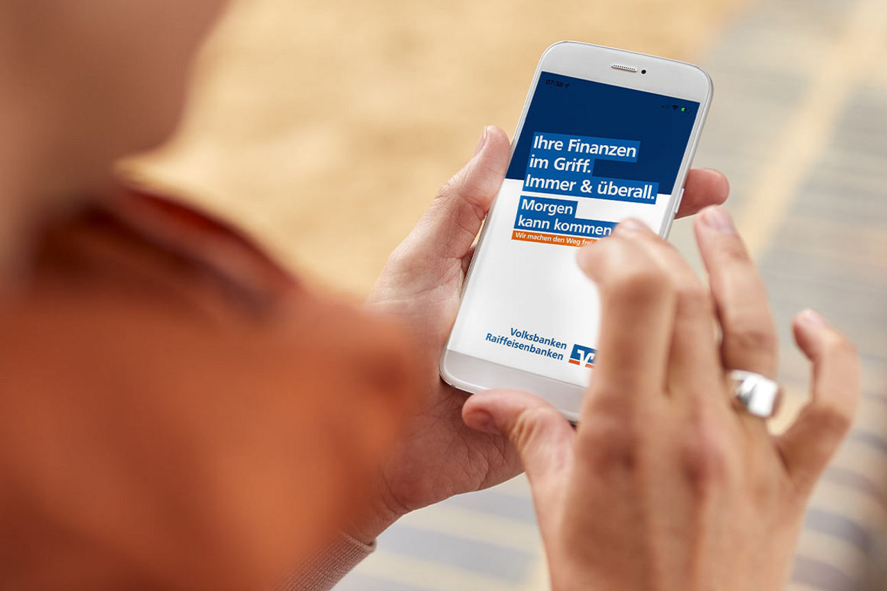 Frau schaut auf die VR Banking App in ihrem Smartphone