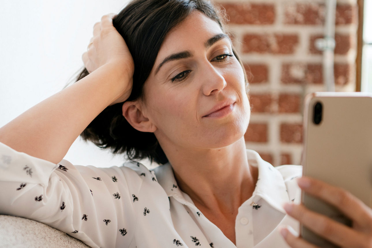 Junge Frau mit einem Handy in der Hand