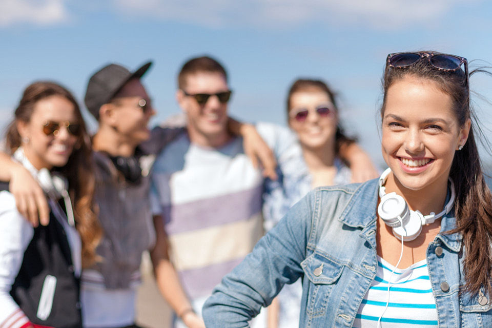 Junge Erwachsene stehen am Strand