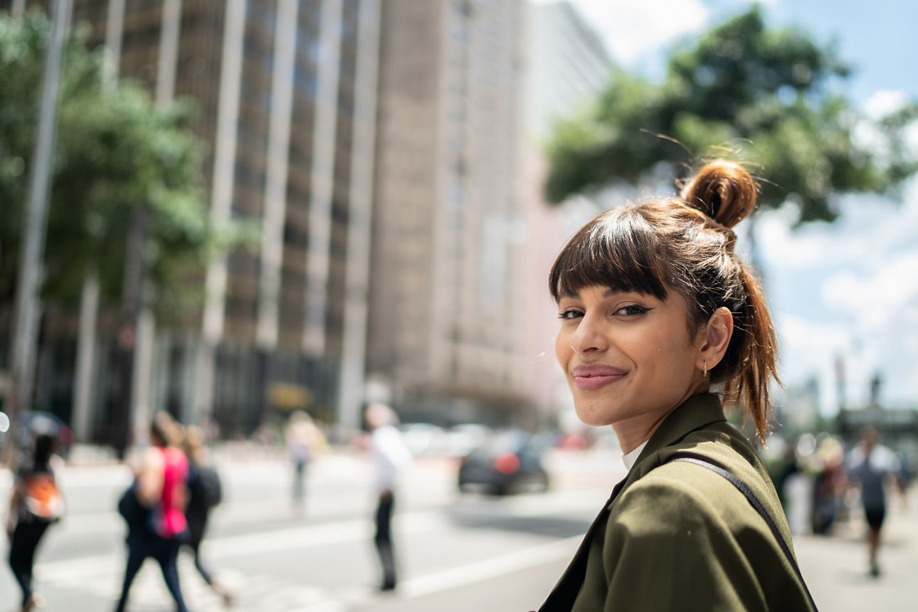 Mann auf einem Bahnhof mit Handy und Koffer in der Hand