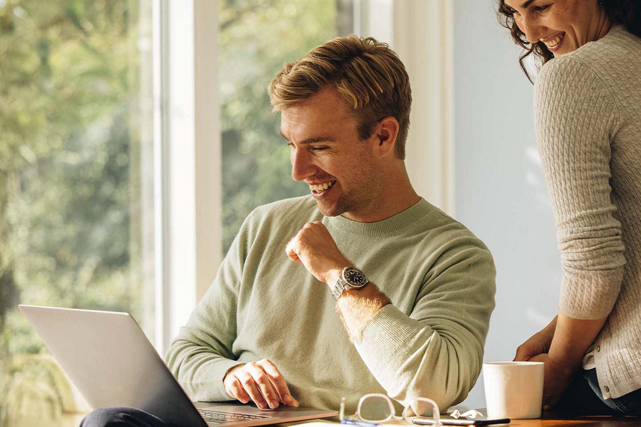 Junges Paar sitzt vor einem Laptop und nutzt unseren digitalen Kontowechselservice