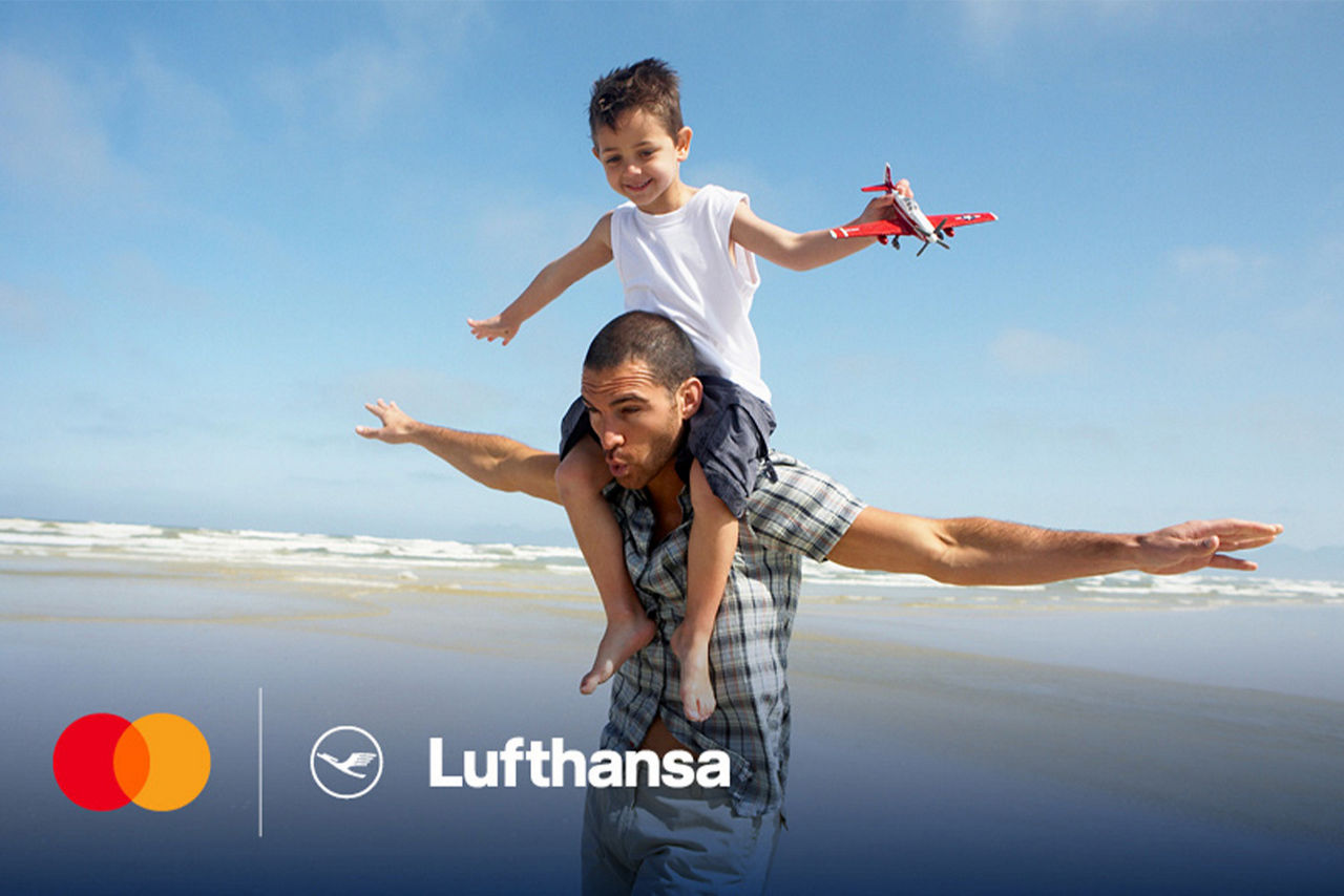 Vater mit seinem Sohn auf dem Rücken am Strand