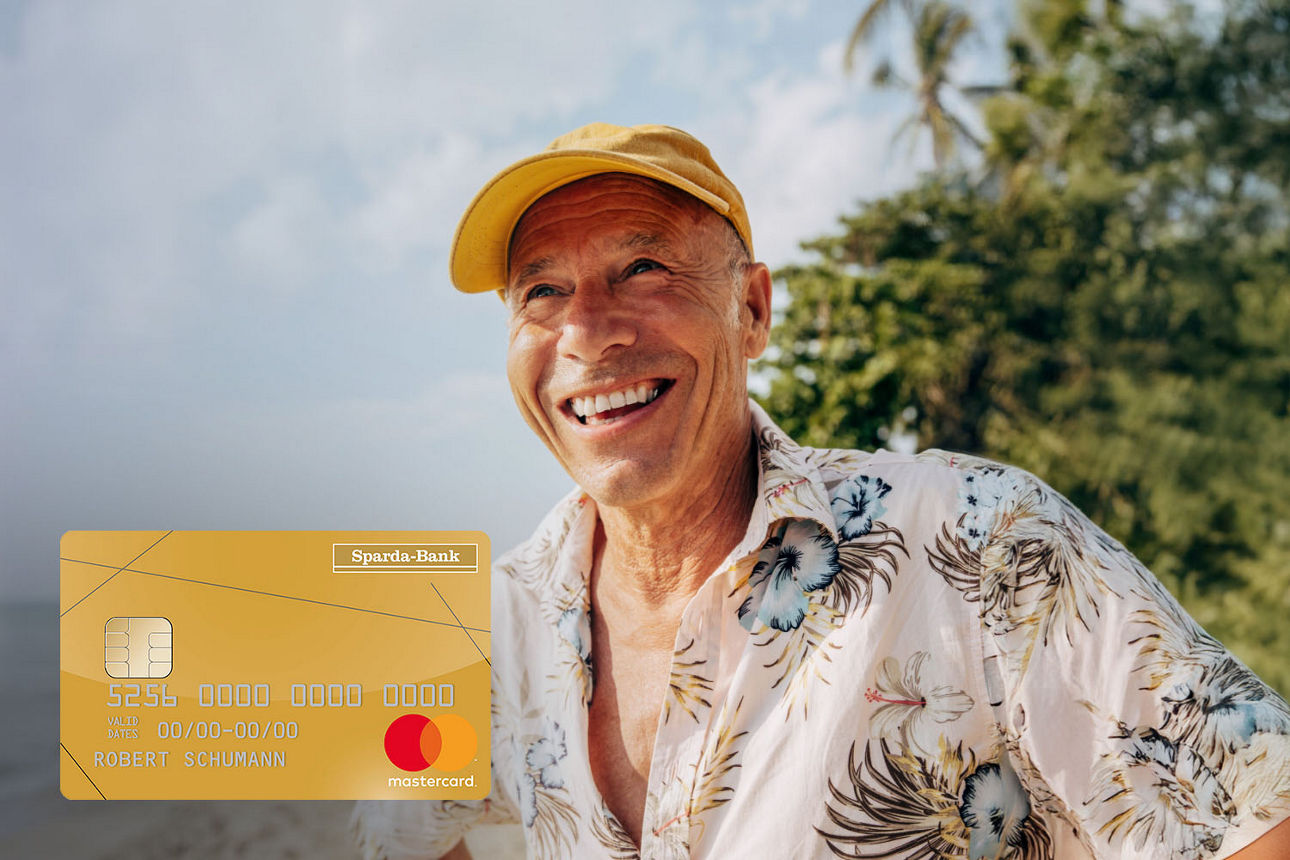 Mann im Sommerfeeling am Strand mit einer Mastercard Gold