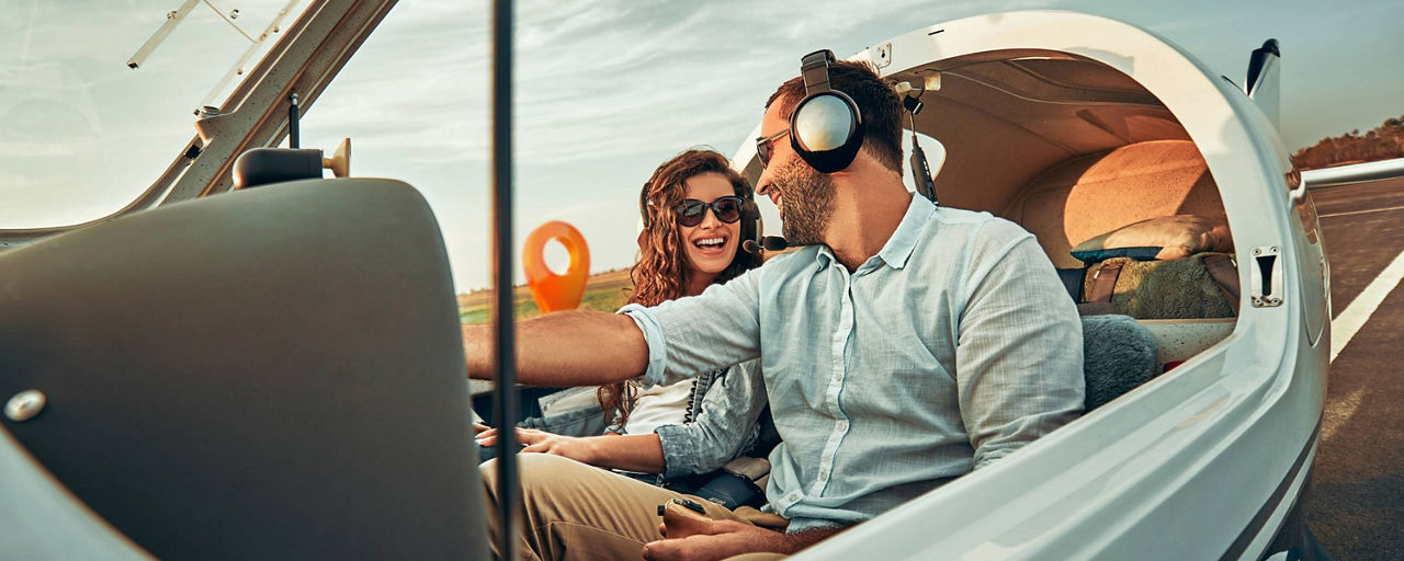 Pärchen im Privatflieger lachen sich an