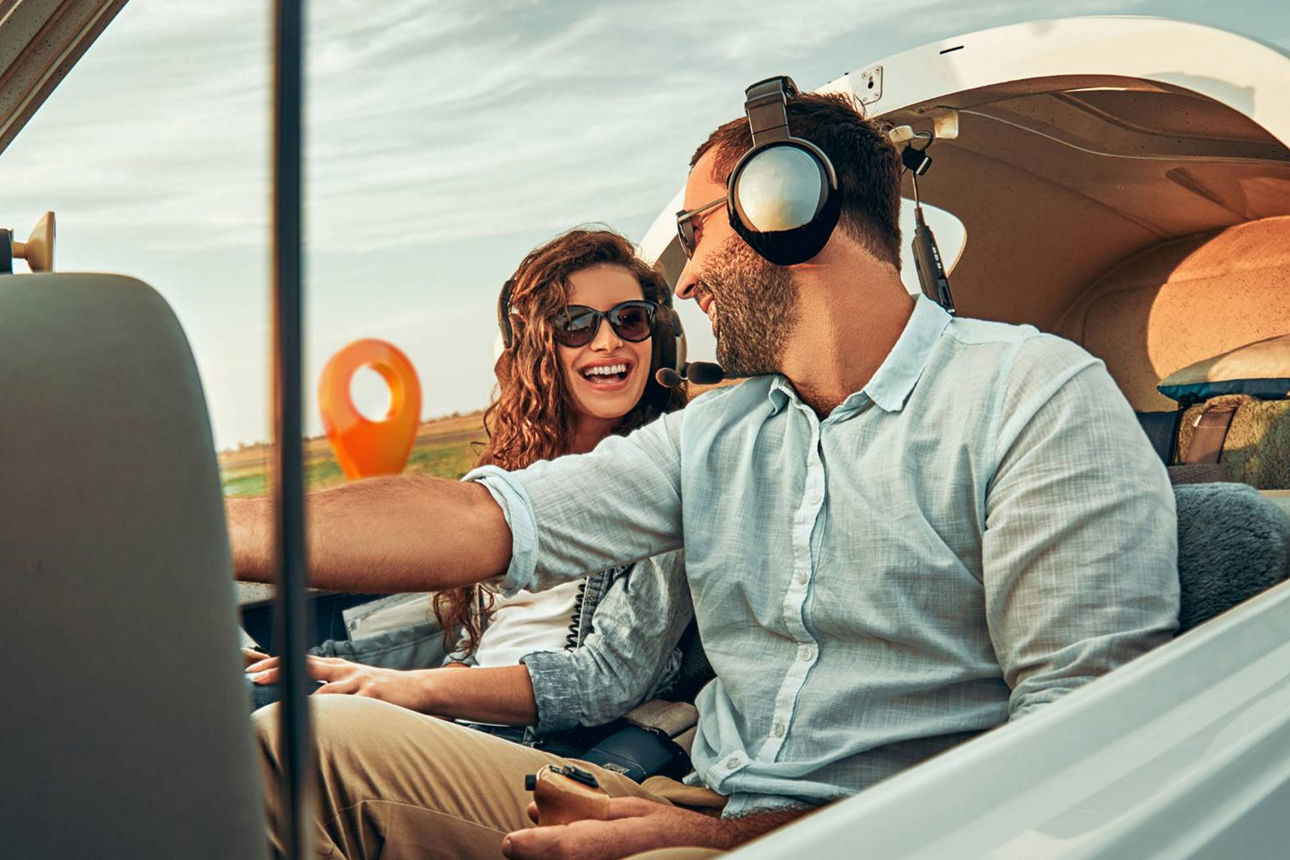 Pärchen im Privatflieger lachen sich an
