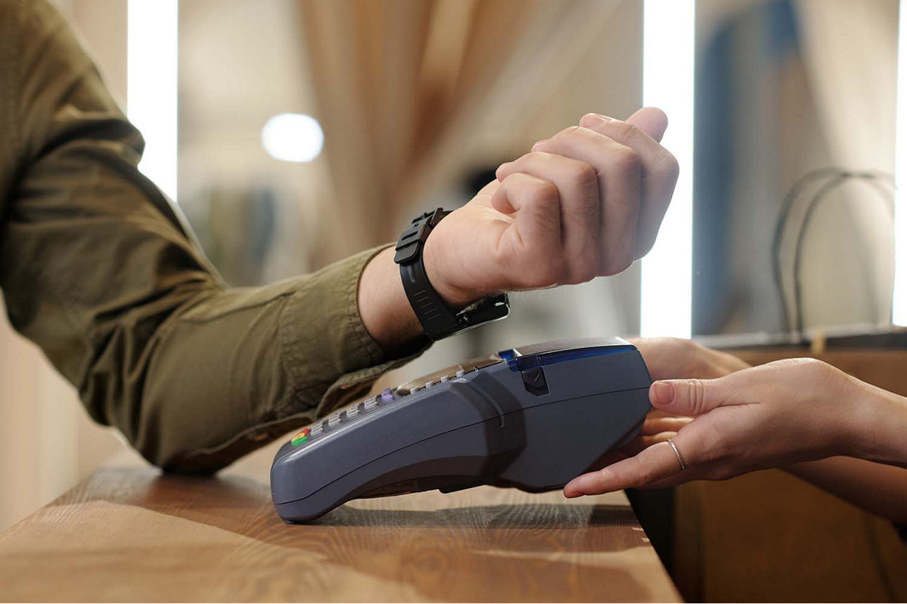 Ein Mann zahlt mit der Smartwatch im Geschäft