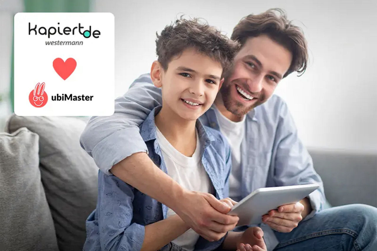 Vater mit seinem Sohn auf der Couch mit einem Tablet in der Hand
