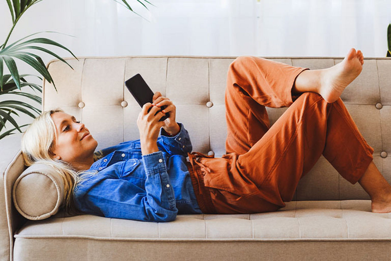 Frau auf Couch mit Handy