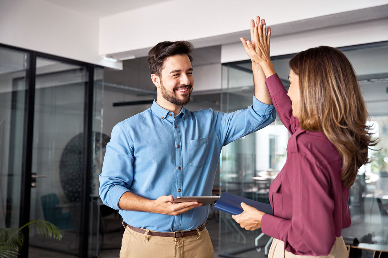 givve® Card - Ein Mann und eine Frau geben sich ein High-Five.