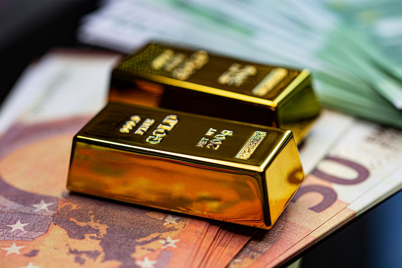 Zwei Goldbarren liegen auf Euro-Banknoten, Nahaufnahme, Symbol für Reichtum, Geldanlage und finanzielle Sicherheit