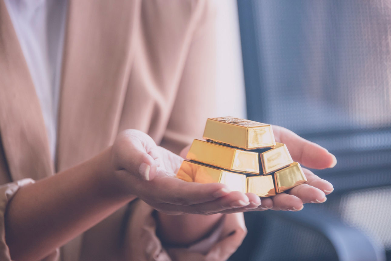 Gold online kaufen Frau hält 6 kleine Goldbarren in ihren Händen