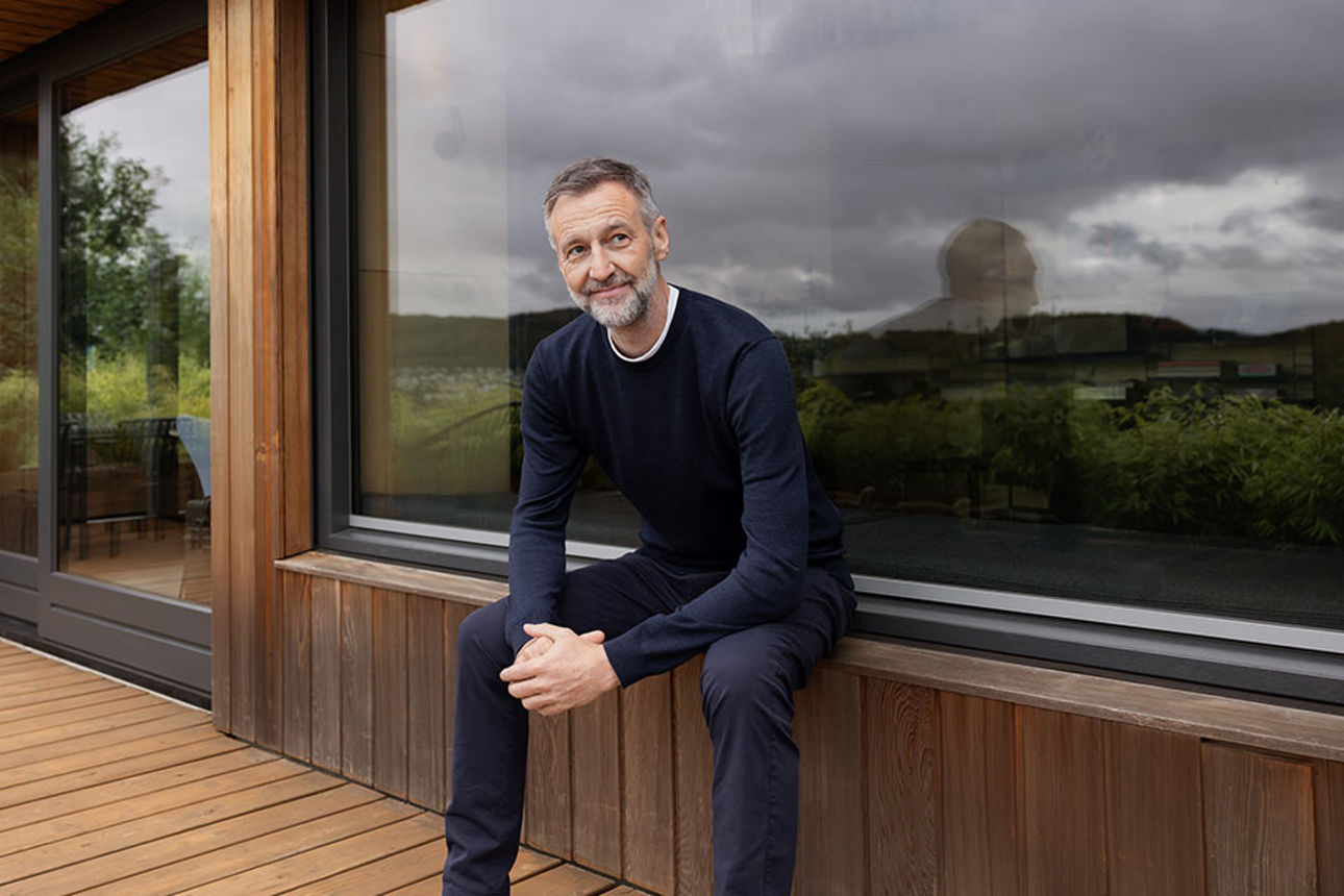 Ein Mann sitzt auf einer Terrasse