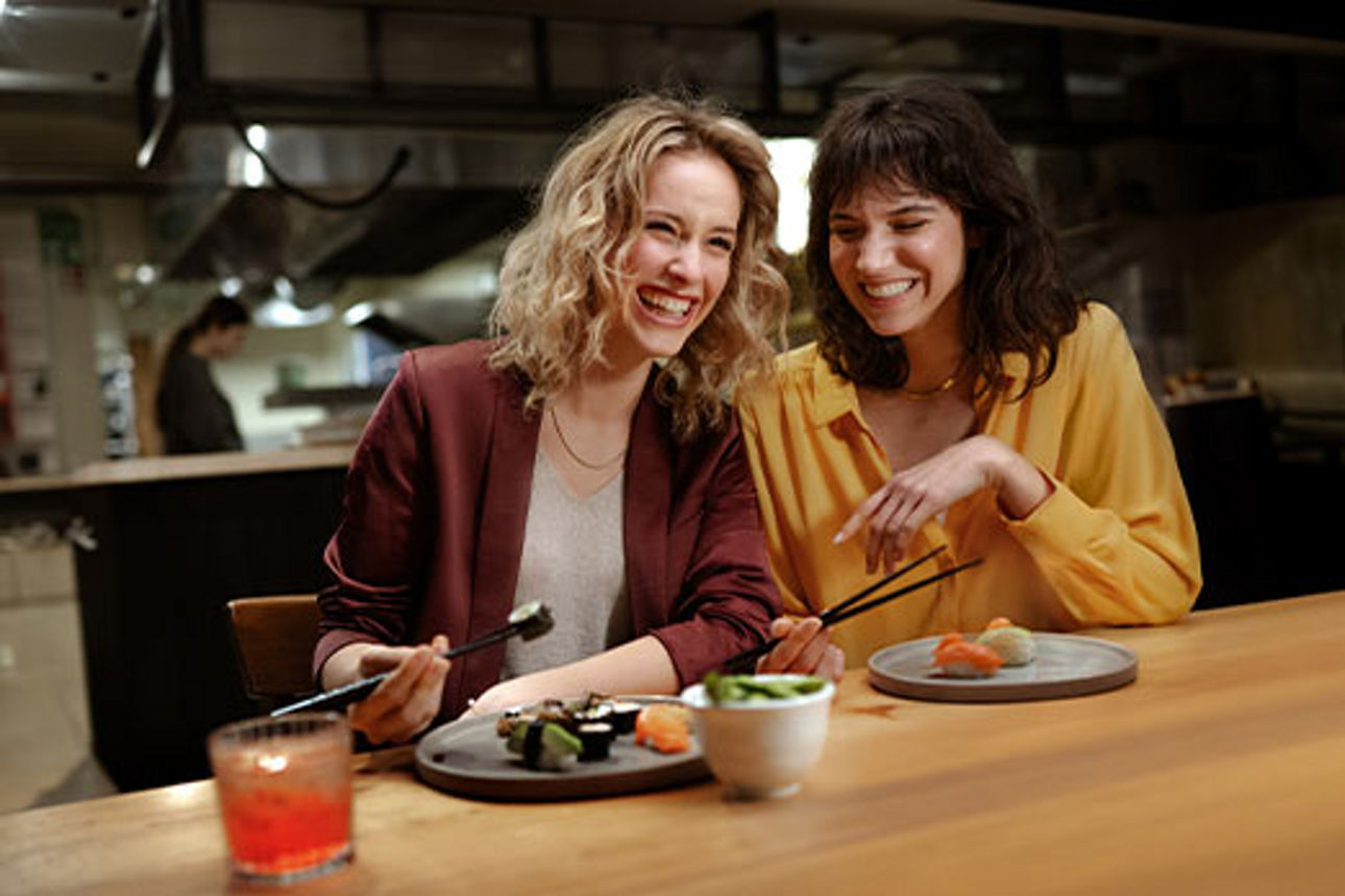 Zwei Freundinnen essen Sushi in einem Restaurant