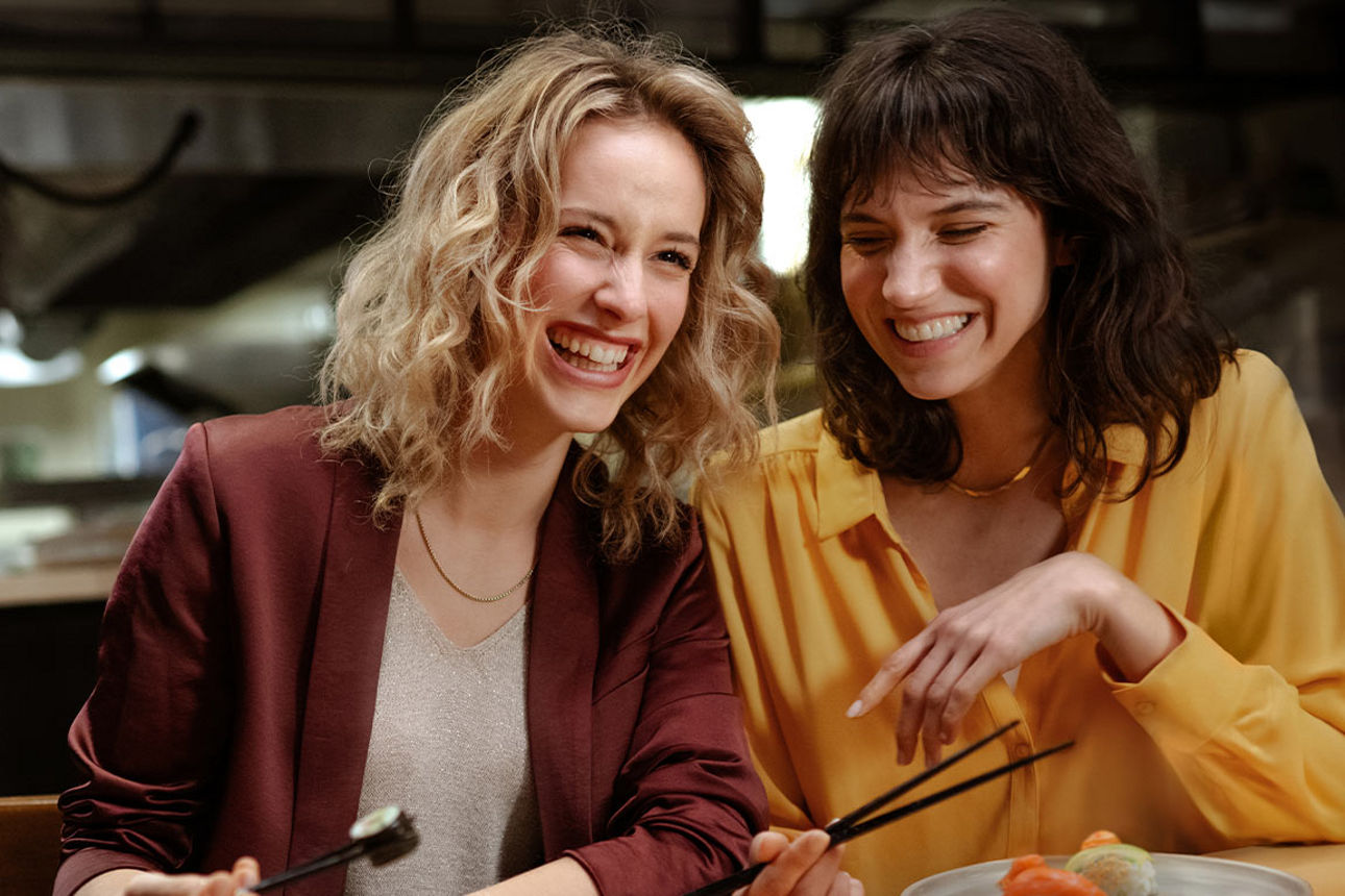 Zwei Junge Frauen lachen im Restaurant bezahlen mit der GoldCard