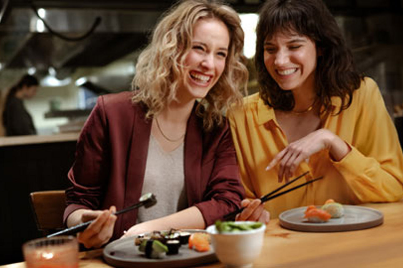 Eine Familie, die sich in einem Restaurant um einen Tisch versammelt hat, um gemeinsam zu essen, zu lachen und sich zu unterh
