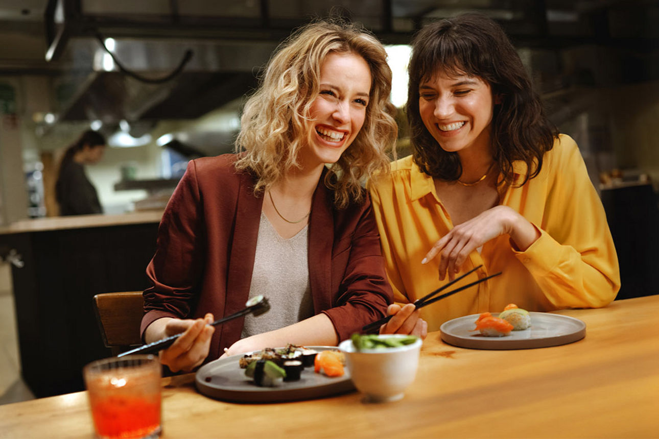 Zwei Freundinnen essen Sushi in einem Restaurant