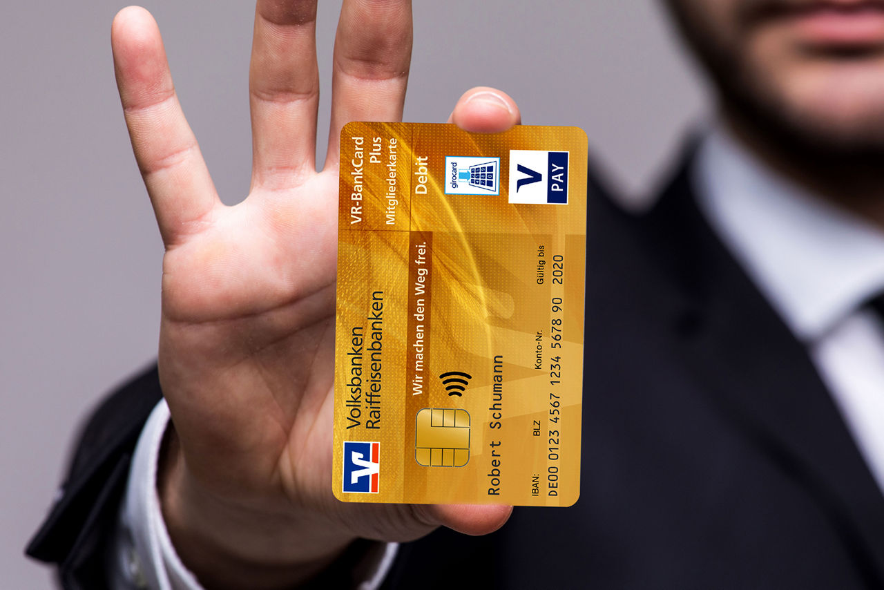 Hand zeigt goldene Girocard