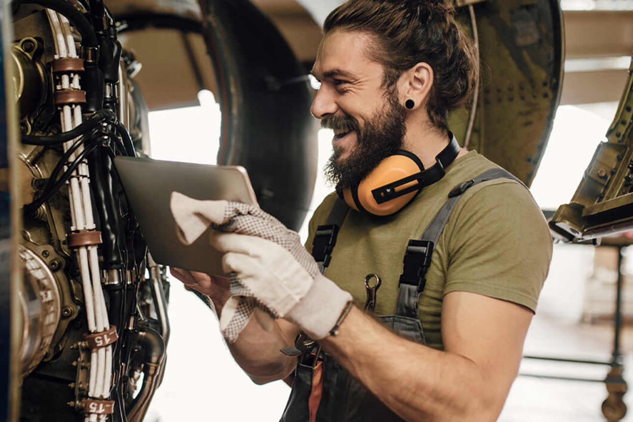 Ein Techniker steht lachend vor einer Maschine