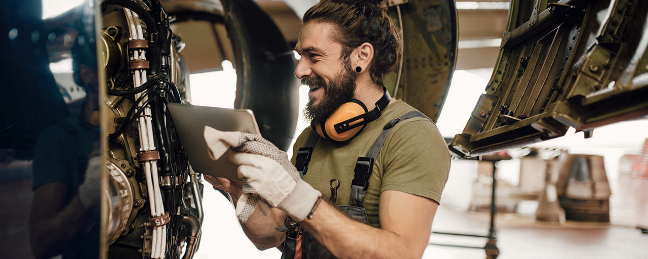 Ein Techniker steht lachend vor einer Maschine