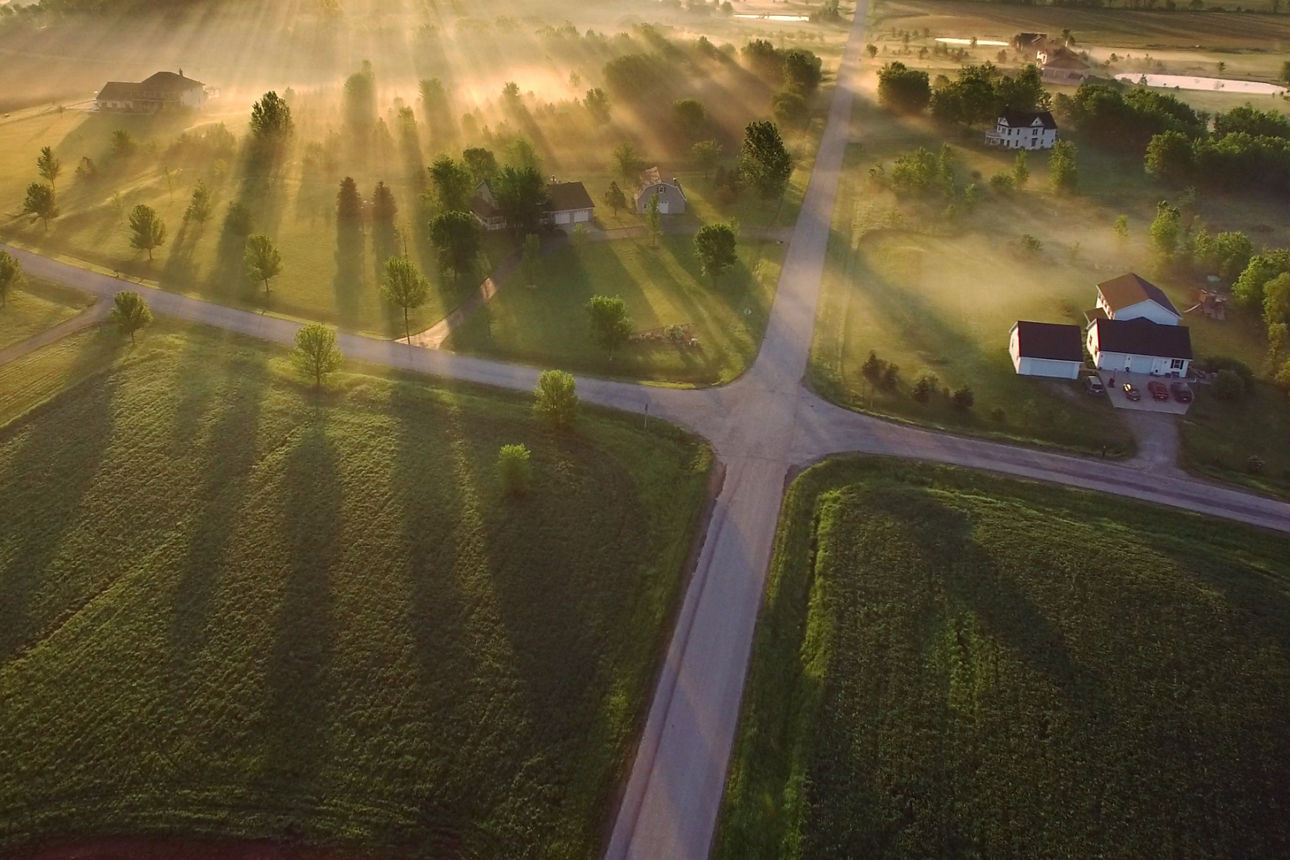Ein magischer Sonnenaufgang durch Nebel am Boden, mit langen Schatten und durchdringenden Sonnenstrahlen.